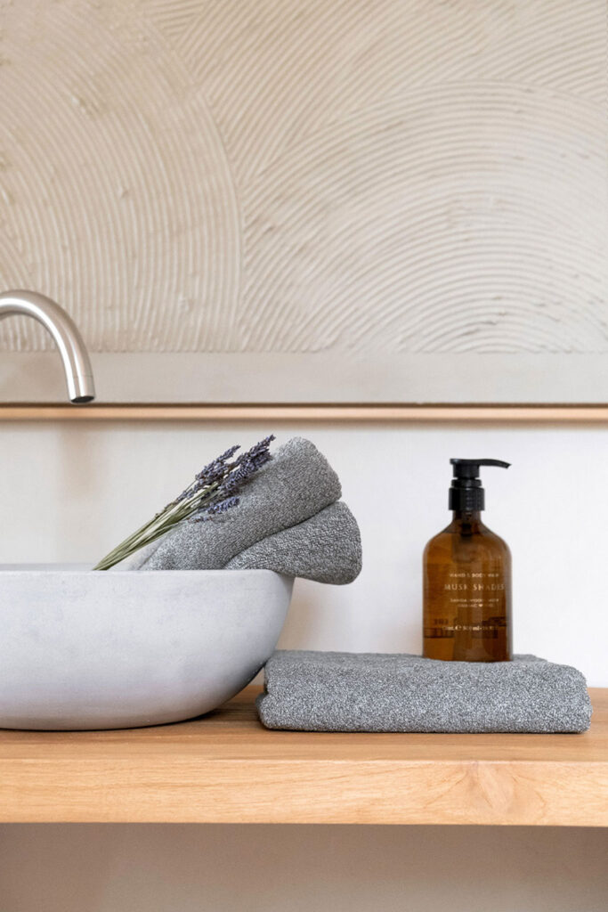 Textiles de baño con toallas grises en alojamiento turístico