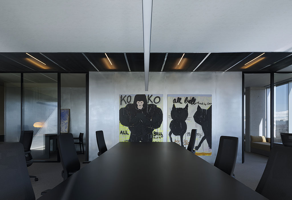 Sala de trabajo de las oficinas de Jungle en Madrid con mesa negra y cerramientos de vidrio.